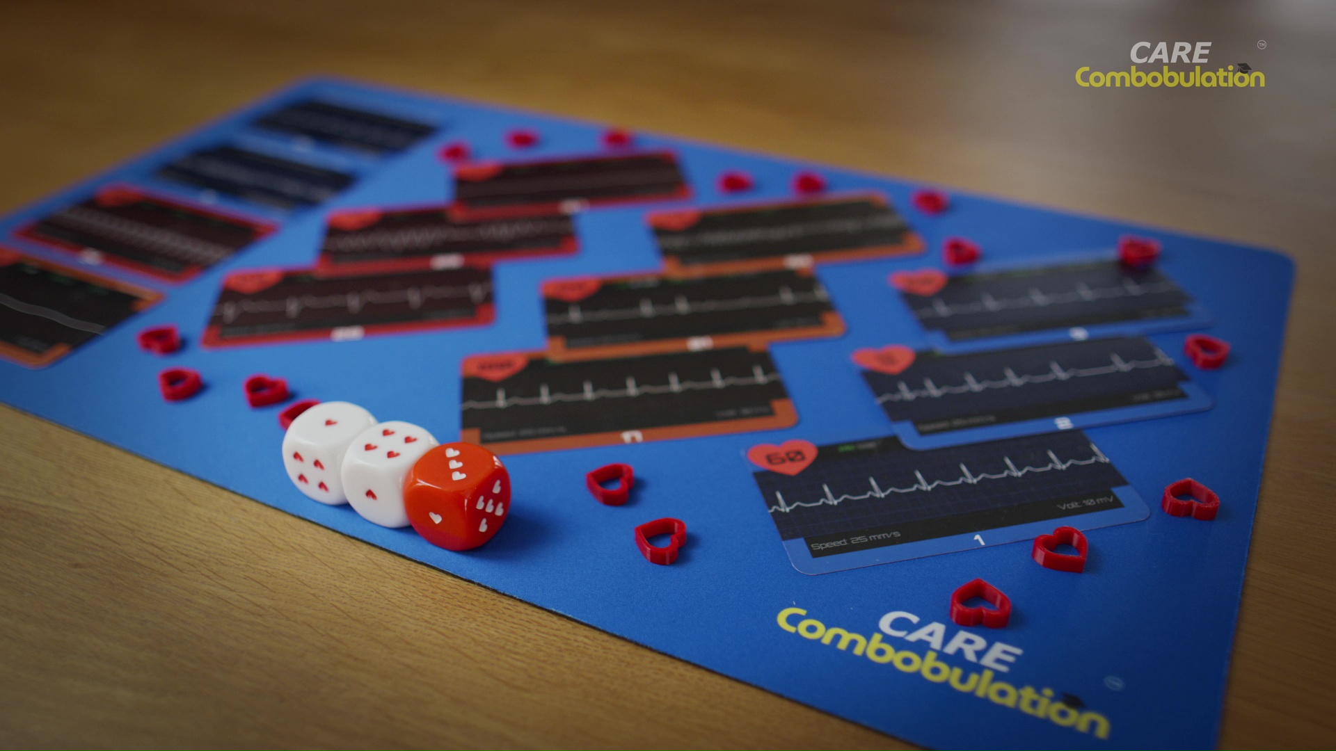 ECG Race rhythm cards, heart counters and dice arranged on a blue playing mat
