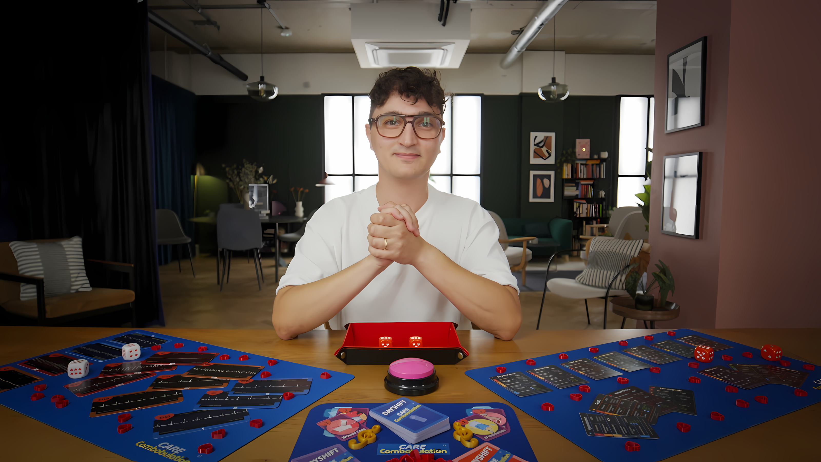 Emanuele Musumeci seated at a table with Dayshift boards, game cards, and dice