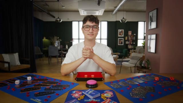 A presenter seated behind a table of CareCombobulation games